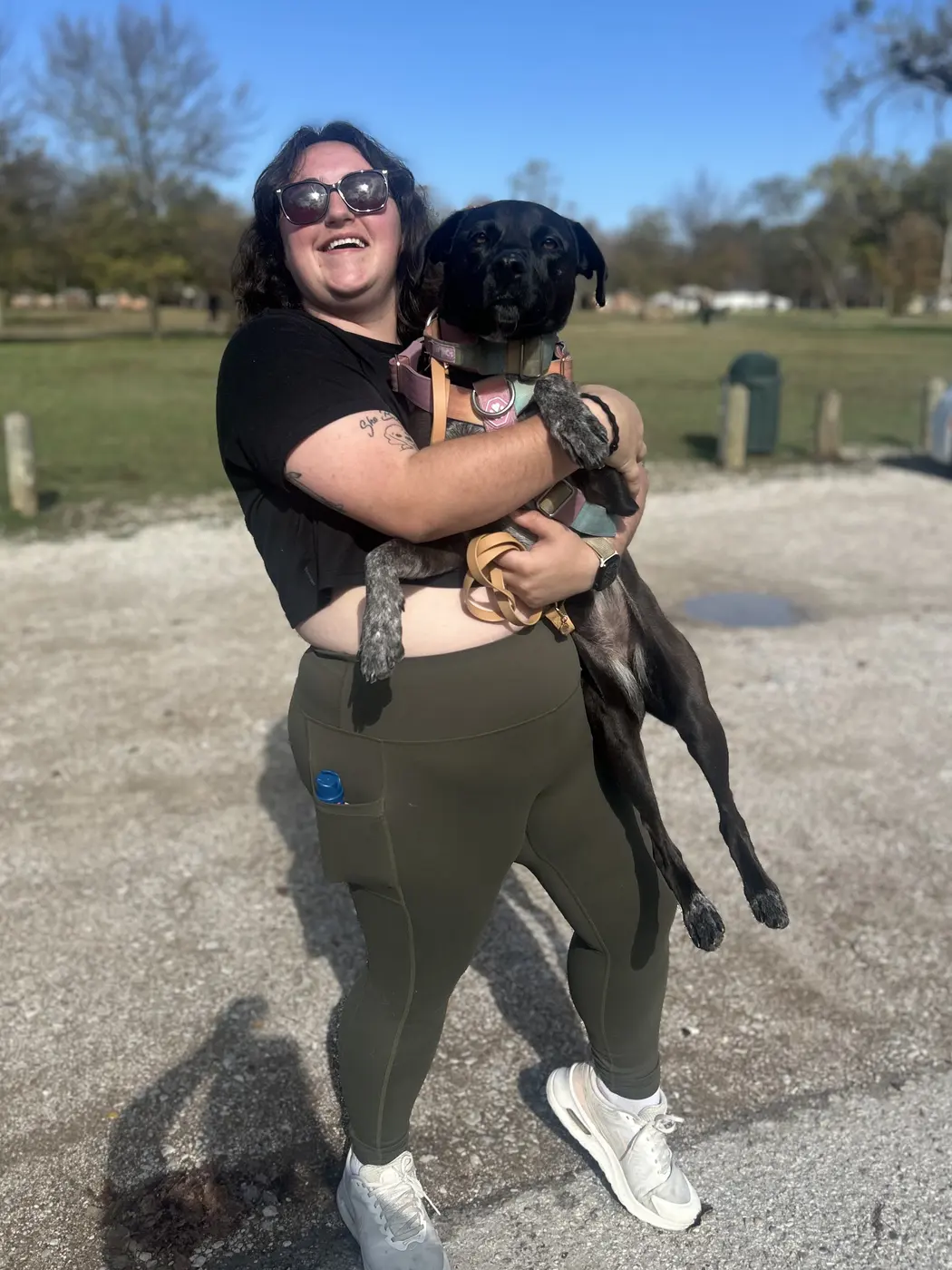 Kourtenay laughing while holding Stinky in her arms at a park on the day Stinky was adopted